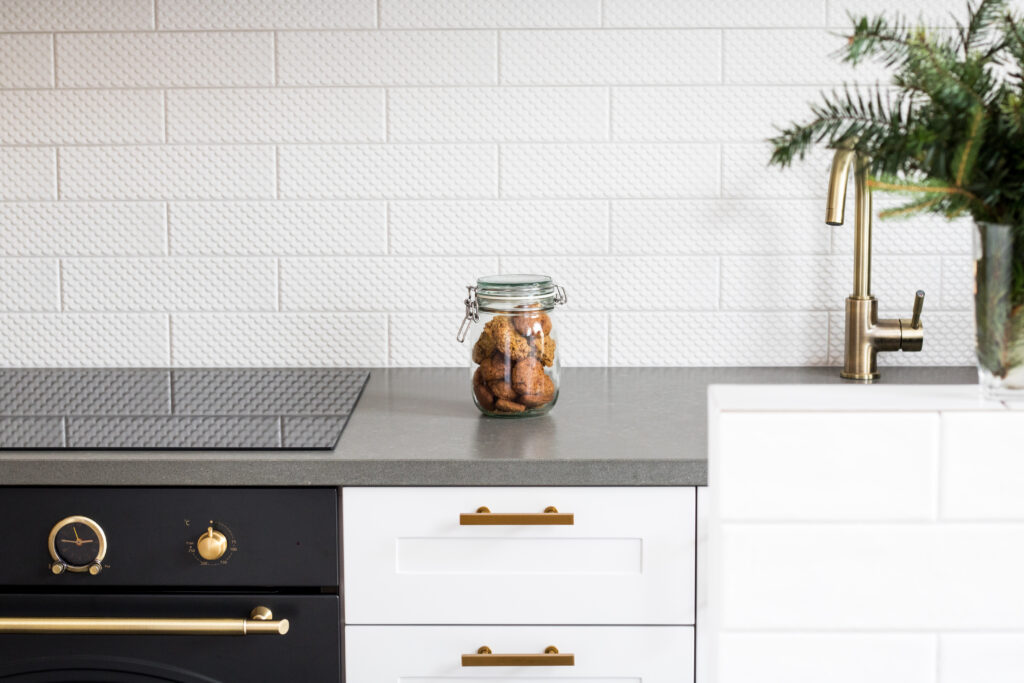 Close up on a white kitchen with grey details, representing the importance of selecting the best countertop and backsplash combinations.