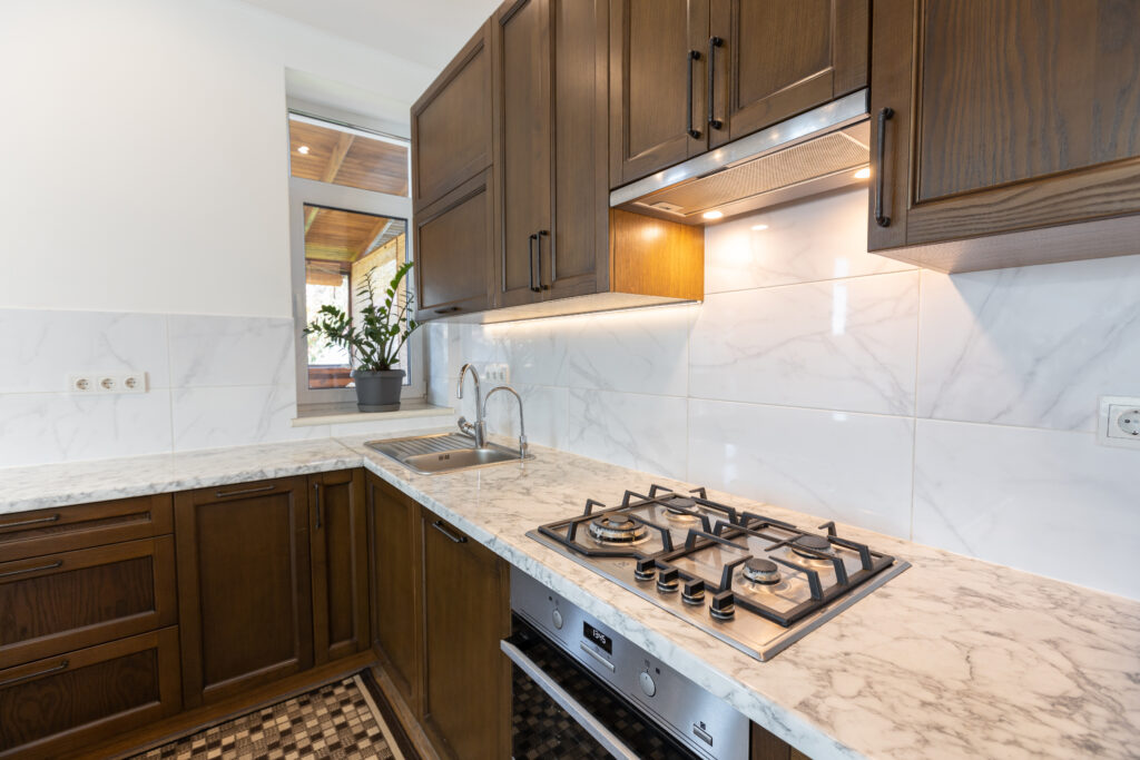 White kitchen with wooden cabinets, representing the importance of selecting the right countertop and backsplash combinations