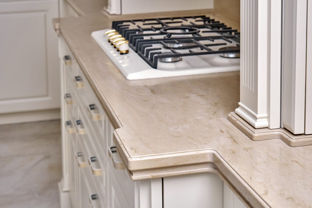 Gas stove on clean acrylic solid surface countertop in modern kitchen, representing countertop trends.